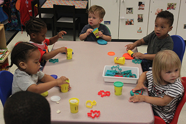 Toddlers playing with Play Doh at Bright Futures Early Scholars Academy